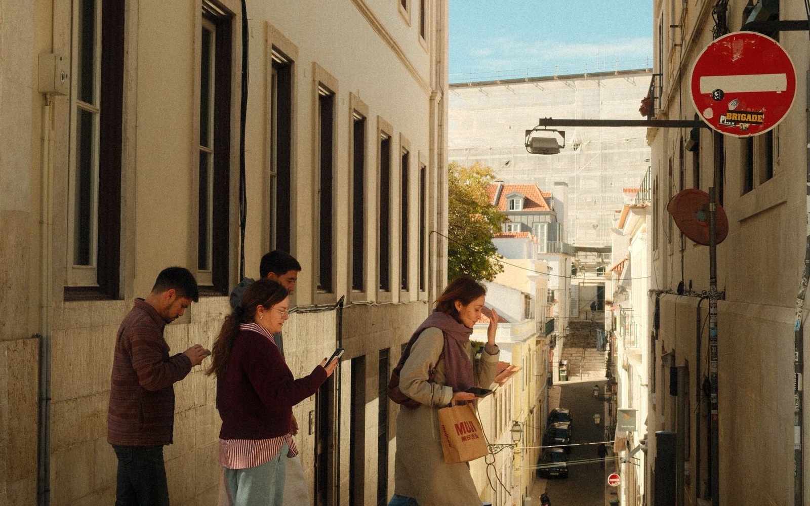 People crossing a cobbled street in Lisbon